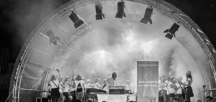 DJ Andy Saarland legt auf und begeistert Gäste bei einem öffentlichen Party Event mit mitreißender Musik
